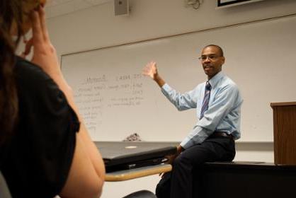 Instructor gestures towards a white board